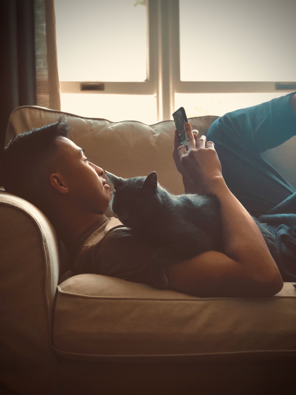 Someone relaxing on the sofa with their cat