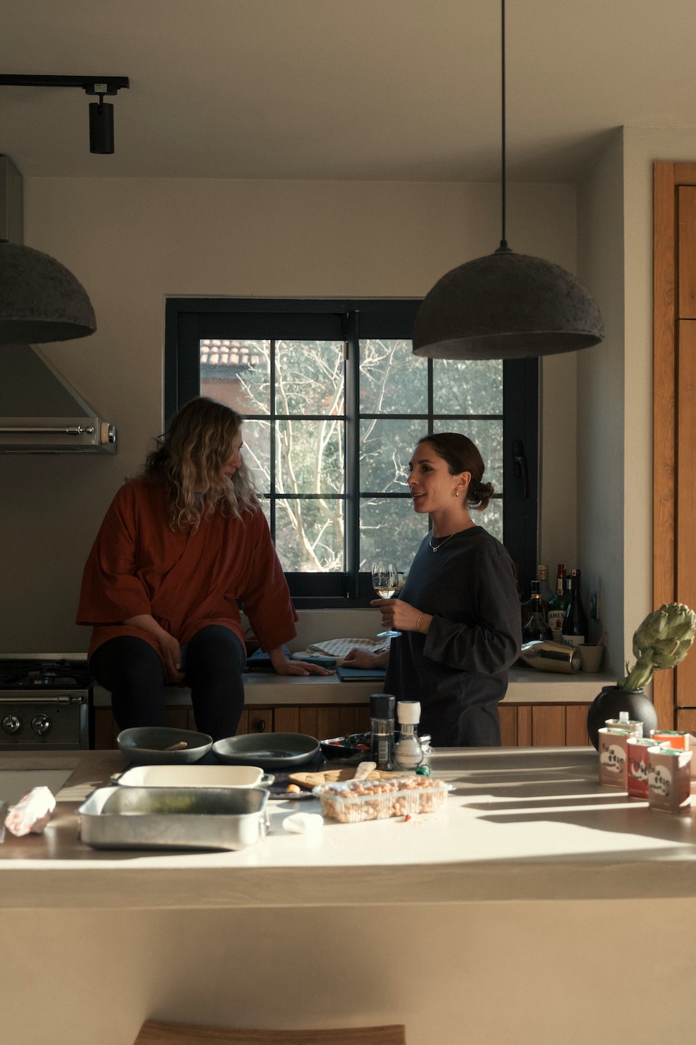 Two people talking in a sunlit kitchen